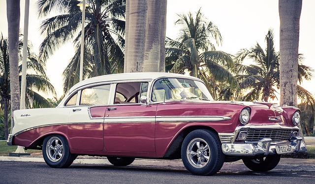 Zabytkowy Cadillac w kolorze czerwono białym, pod palmami na Florydzie.